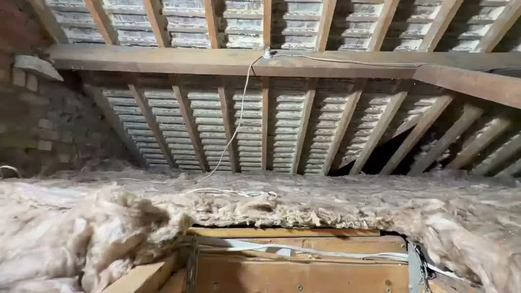 Old, disturbed insulation on an unboarded loft floor