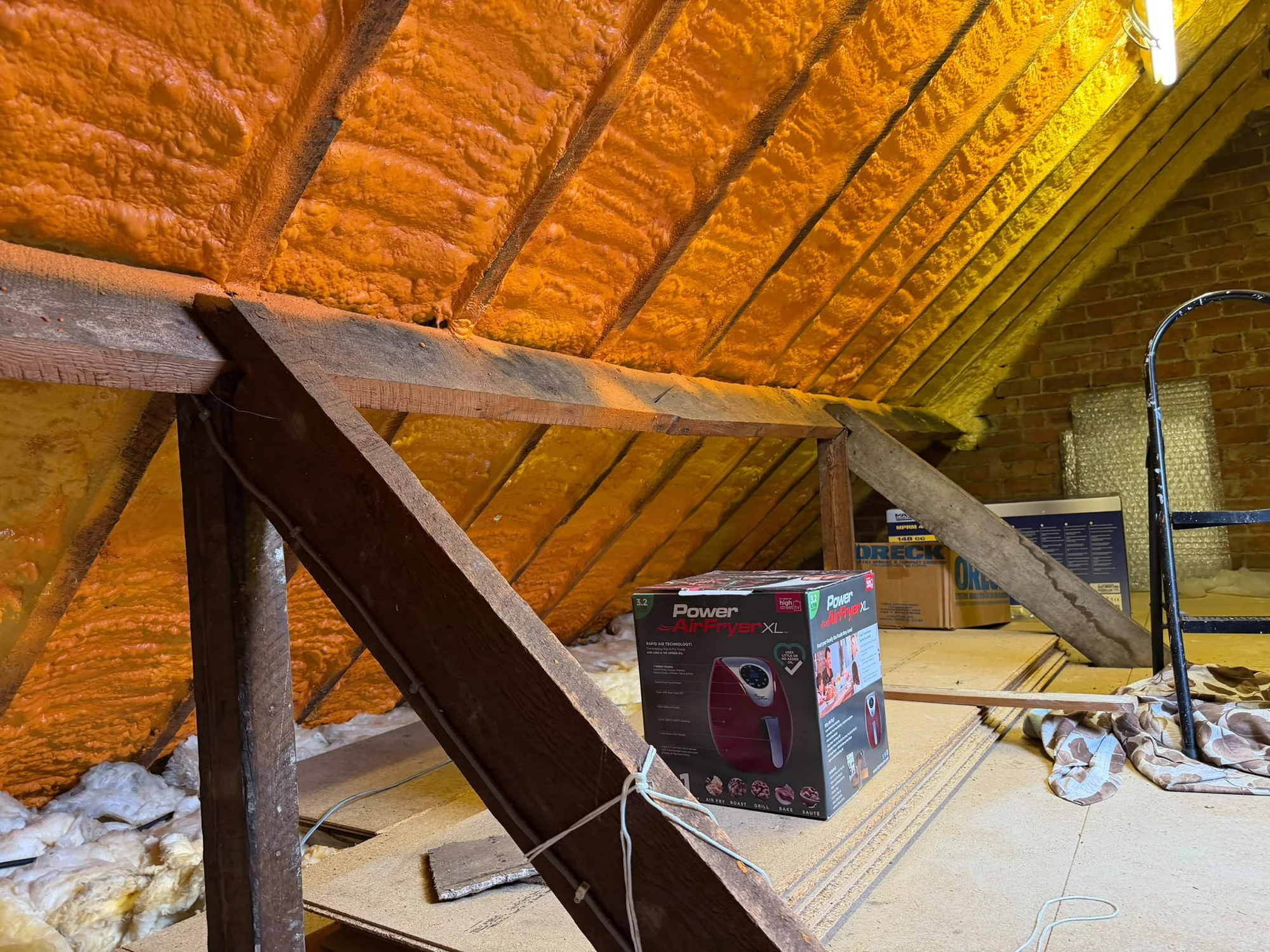 Spray foam clinging to the roof slopes, timbers hidden